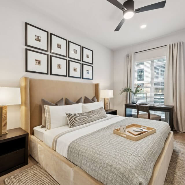 bedroom with a large window and ceiling fans